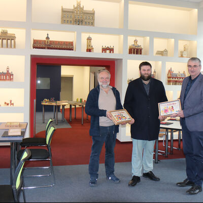 Bild vergrößern: Hans-Heinrich Tschoepke (li.) zeigte MdL Moritz Kalthoff und Landrat Marko Wolfram die neue Ankerstein-Erlebniswelt mit dem "Setzkasten" im Hintergrund.