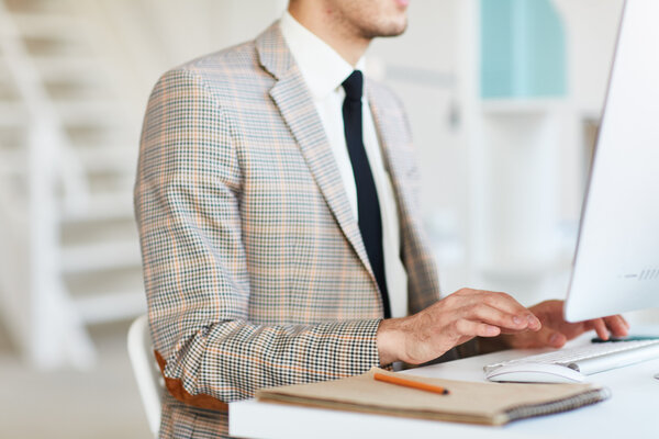 Bild vergr&ouml;&szlig;ern: Person vor einem Monitor sitzend. Stift und Papier liegen bereit.